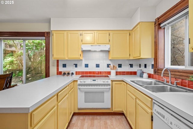 3147 SE Belmont St, Portland, OR 97214 - kitchen with white appliances, under cabinet range hood, a peninsula, and light countertops