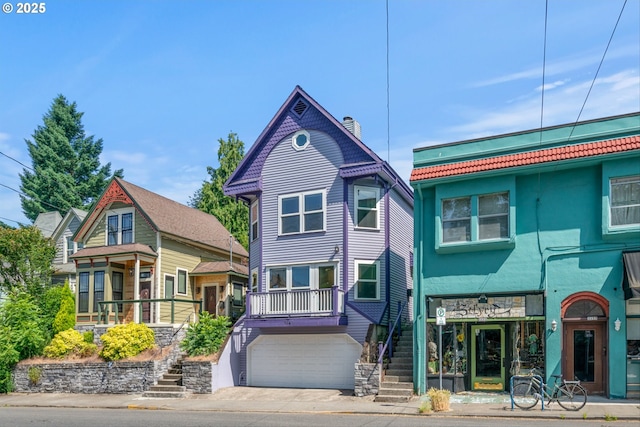 3147 SE Belmont St, Portland, OR 97214 - victorian house with stairway, a garage, stone siding, and driveway