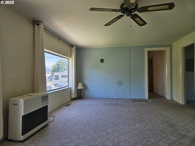 333 3rd St, Richland, OR 97870 - unfurnished bedroom featuring carpet floors, brick wall, a textured ceiling, a ceiling fan, and heating unit