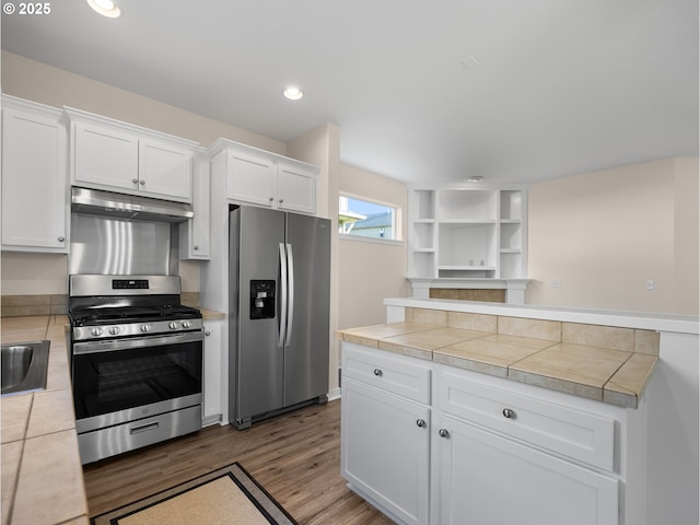 kitchen featuring white cabinetry, appliances with stainless steel finishes, tile countertops, and hardwood / wood-style flooring