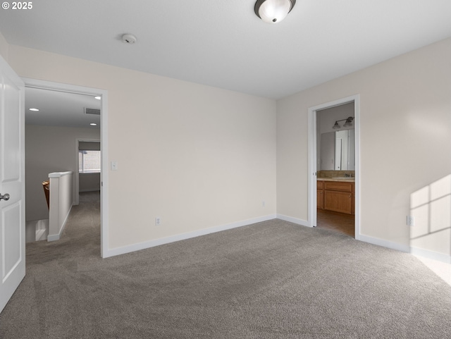 unfurnished bedroom featuring ensuite bathroom and carpet floors