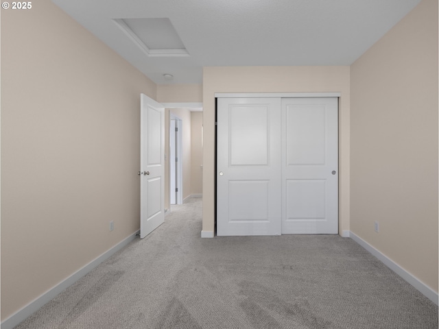 unfurnished bedroom featuring light carpet and a closet