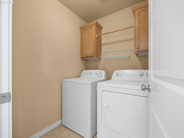 laundry room featuring cabinets, washing machine and clothes dryer, and light tile patterned floors