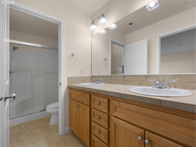 bathroom with vanity, a shower with door, and toilet