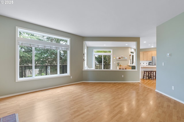 unfurnished living room featuring light wood finished floors, baseboards, visible vents, and recessed lighting