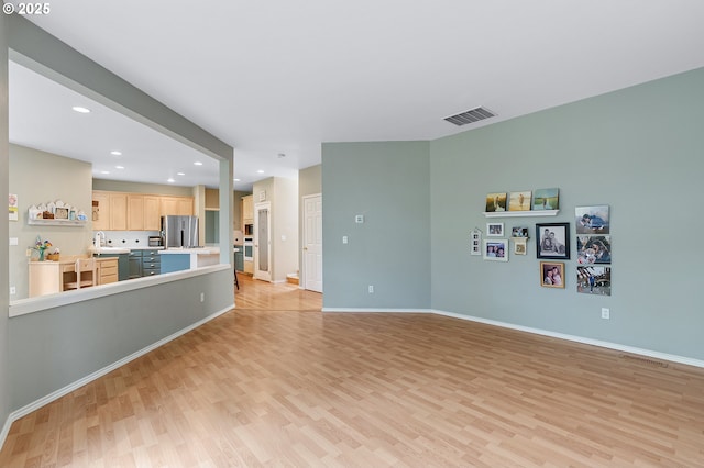 living area featuring light wood finished floors, baseboards, visible vents, and recessed lighting