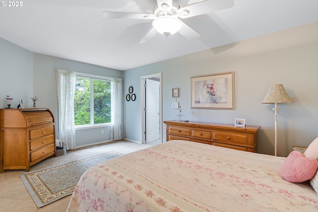 bedroom with light colored carpet, baseboards, and a ceiling fan