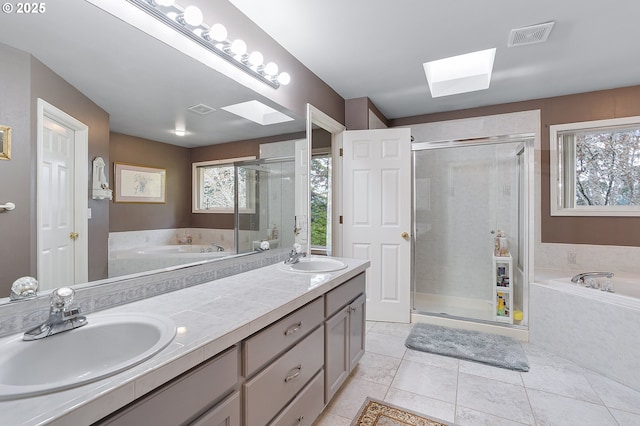bathroom with a sink, visible vents, a skylight, and plenty of natural light