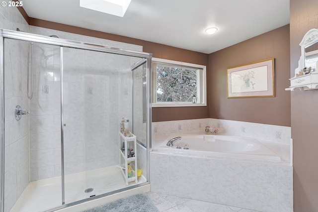 bathroom with a stall shower, a garden tub, tile patterned floors, and a skylight