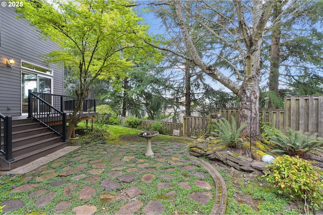 view of yard with a wooden deck, a fenced backyard, and a patio area