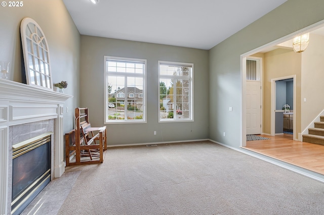 sitting room featuring a fireplace, stairway, baseboards, and carpet floors