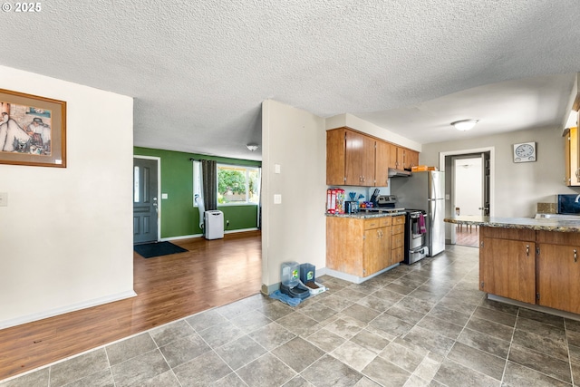 9304 NE 96th St, Vancouver, WA 98662 - kitchen featuring stainless steel range with electric cooktop, under cabinet range hood, brown cabinets, a textured ceiling, and light countertops