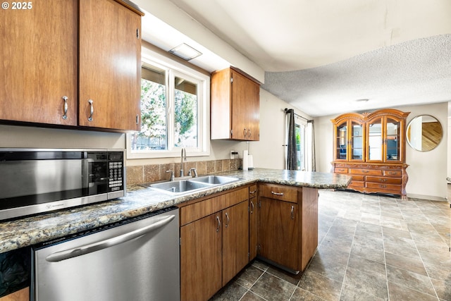 9304 NE 96th St, Vancouver, WA 98662 - kitchen featuring stainless steel appliances, plenty of natural light, a peninsula, a textured ceiling, and brown cabinetry