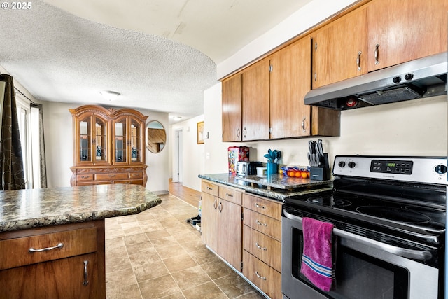 9304 NE 96th St, Vancouver, WA 98662 - kitchen featuring stainless steel electric stove, under cabinet range hood, dark countertops, a textured ceiling, and brown cabinetry