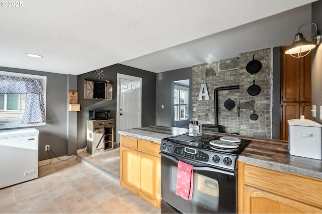 kitchen with a wealth of natural light, light brown cabinetry, and black appliances