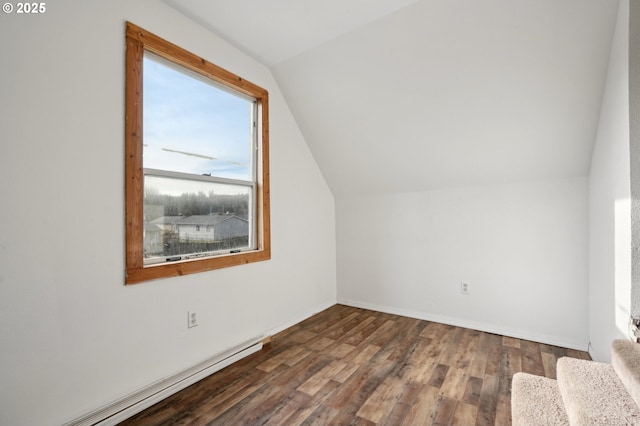 additional living space with vaulted ceiling, a baseboard heating unit, and dark hardwood / wood-style floors