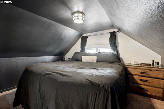 carpeted bedroom with vaulted ceiling and a textured ceiling