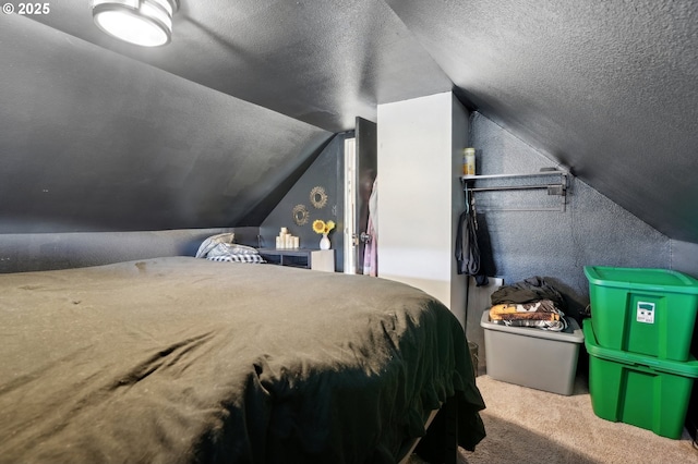 carpeted bedroom with vaulted ceiling and a textured ceiling