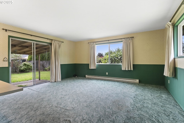 carpeted empty room with a baseboard radiator, wallpapered walls, and wainscoting