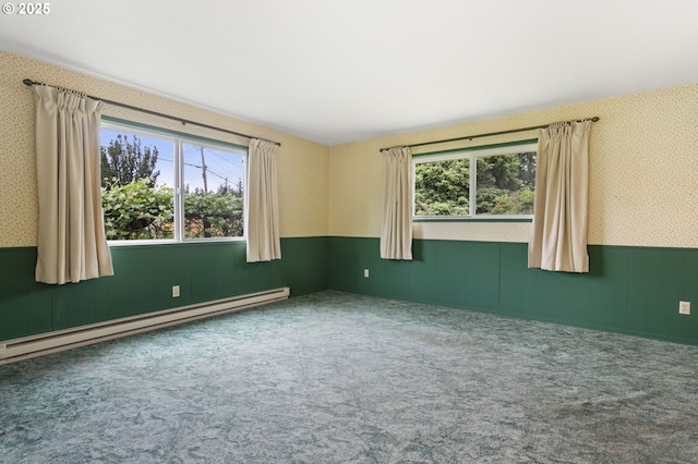 carpeted spare room with baseboard heating, wainscoting, healthy amount of natural light, and wallpapered walls
