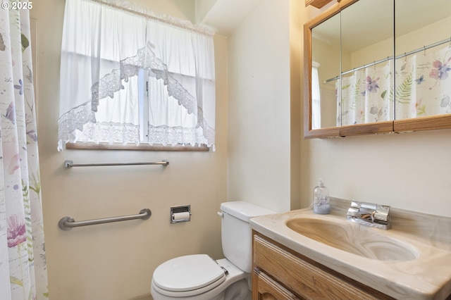 bathroom with toilet, vanity, and curtained shower