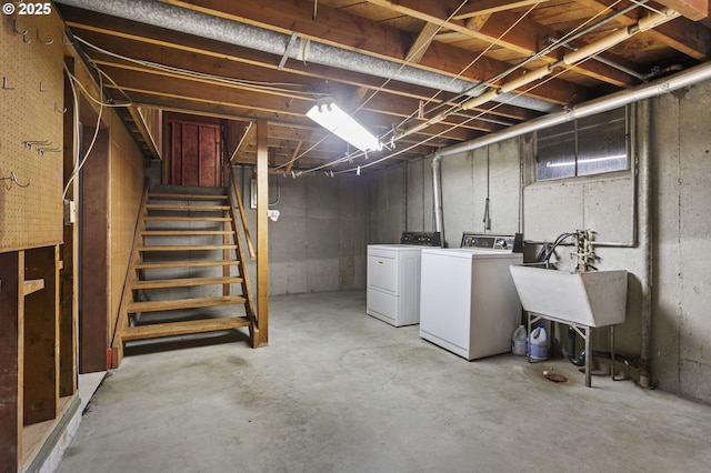 unfinished basement with stairs, a sink, and washing machine and clothes dryer