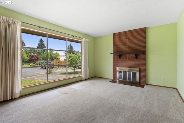 unfurnished living room with carpet floors, a fireplace, and baseboards