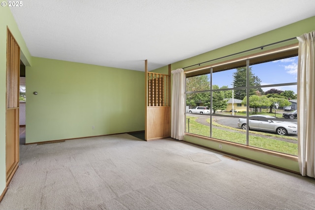 carpeted spare room featuring baseboards