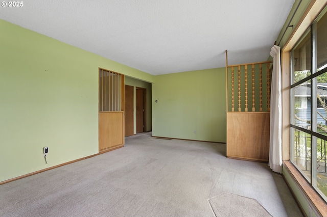 unfurnished room featuring light carpet, healthy amount of natural light, and baseboards