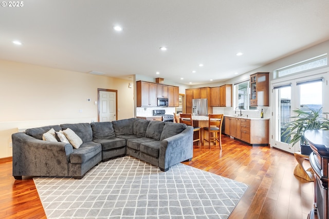 living area with light wood-style flooring and recessed lighting