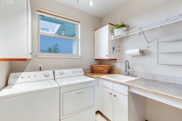 laundry area with cabinet space, washer and clothes dryer, and a sink