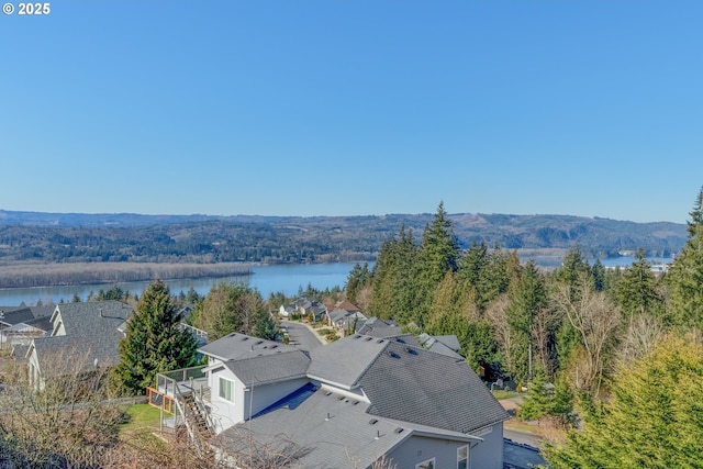 birds eye view of property featuring a water view and a view of trees