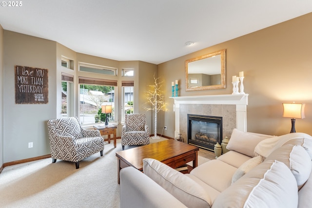 living room with carpet, a tiled fireplace, and baseboards