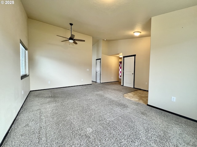 spare room with high vaulted ceiling, carpet flooring, baseboards, and ceiling fan