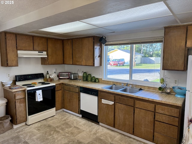 kitchen featuring sink, electric range oven, dishwasher, and a drop ceiling