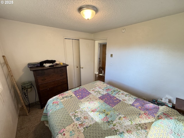 bedroom with a textured ceiling, carpet floors, and a closet