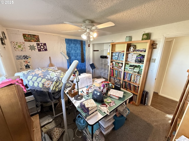 bedroom with a textured ceiling, ceiling fan, and carpet