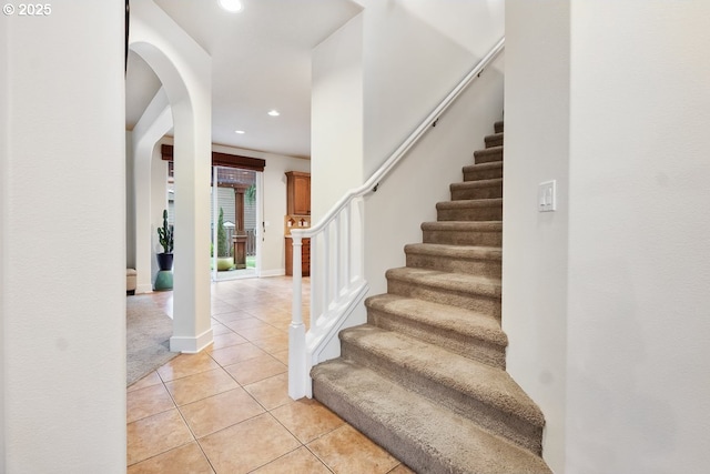 staircase with tile patterned floors, baseboards, and recessed lighting