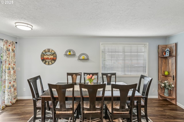 dining space with a textured ceiling, dark wood finished floors, and baseboards