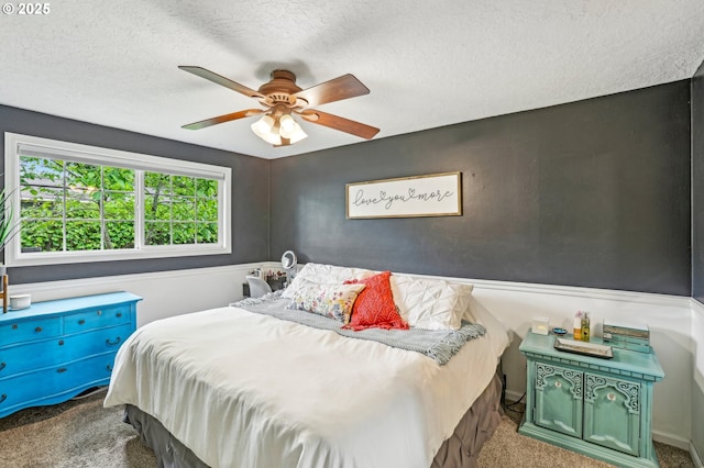carpeted bedroom with a textured ceiling and ceiling fan