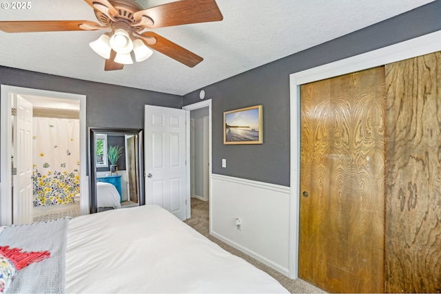 carpeted bedroom featuring a textured ceiling, ceiling fan, and a closet