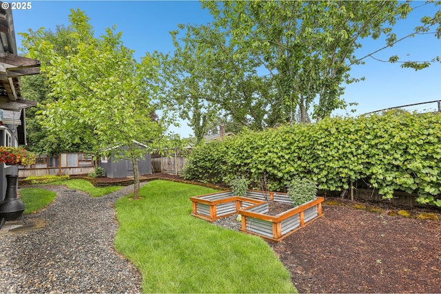 view of yard with a garden, a storage unit, and an outbuilding