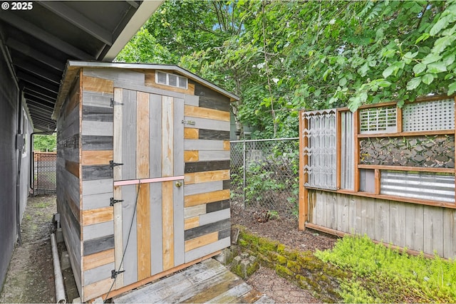 view of outdoor structure featuring fence and an outbuilding