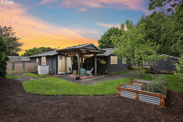 back of property at dusk featuring a storage shed, fence, an outbuilding, a patio area, and central AC
