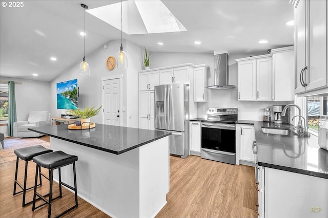 18365 SW Springfield St, Beaverton, OR 97078 - kitchen with appliances with stainless steel finishes, wall chimney range hood, a sink, light wood finished floors, and lofted ceiling
