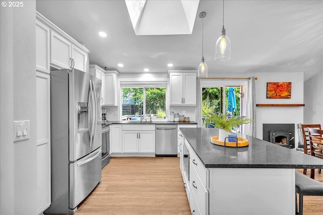18365 SW Springfield St, Beaverton, OR 97078 - kitchen featuring appliances with stainless steel finishes, white cabinetry, a kitchen island, and recessed lighting