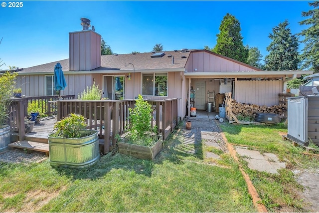 18365 SW Springfield St, Beaverton, OR 97078 - back of property with a wooden deck, a chimney, a yard, board and batten siding, and a shingled roof