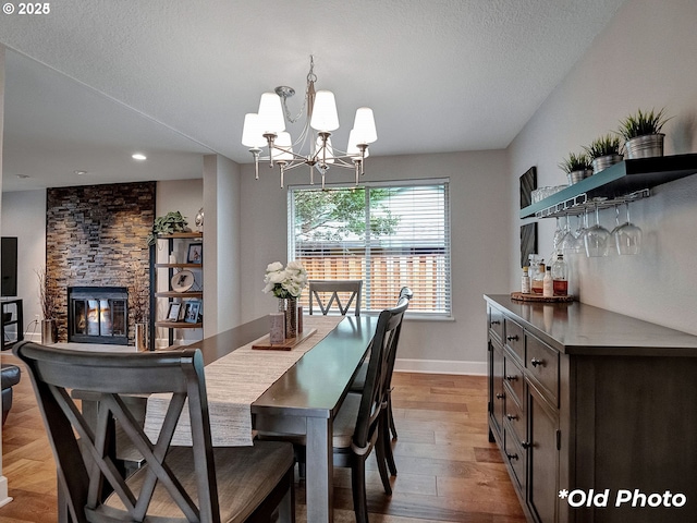 13527 SW Ashbury Ln, Portland, OR 97223 - dining area featuring a chandelier, light wood-style floors, recessed lighting, a stone fireplace, and a dry bar