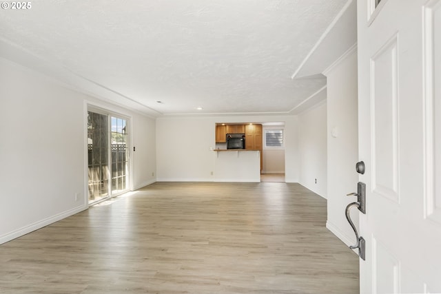 2702 Fairmount Ave, Vancouver, WA 98661 - unfurnished living room featuring ornamental molding, light wood finished floors, baseboards, and a textured ceiling