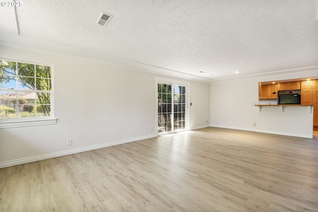 2702 Fairmount Ave, Vancouver, WA 98661 - unfurnished living room with a textured ceiling, light wood-type flooring, baseboards, and crown molding
